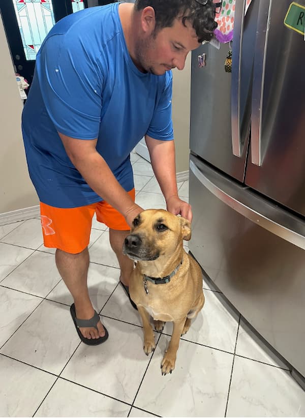 Dog dad applies FRONTLINE Shield for Dogs to back of his dog's neck